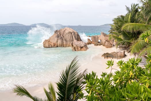 Beach with blue water and blue sky and white sand and some rocks