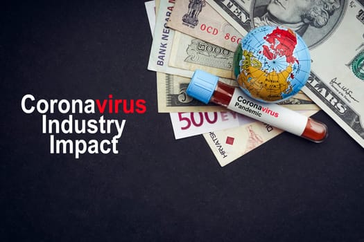 CORONAVIRUS INDUSTRY IMPACT text with currency banknotes, world globe and blood test vacuum tube on black background. Covid-19 or Coronavirus Concept