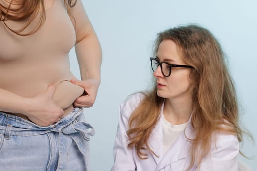attractive woman doctors, Nutritionists is using hand measure size Excess fat Of woman patients who received treatment for obesity On white background to health care concept.