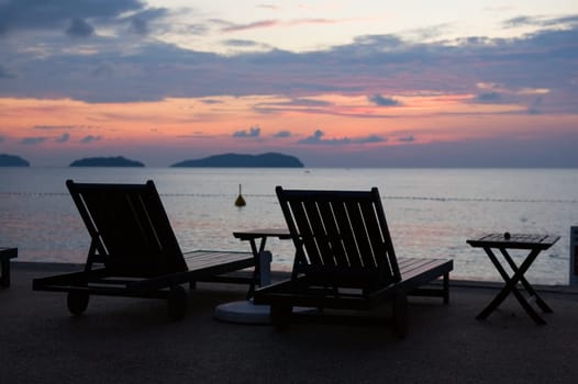 Silhouette of two relaxing seats at seashore