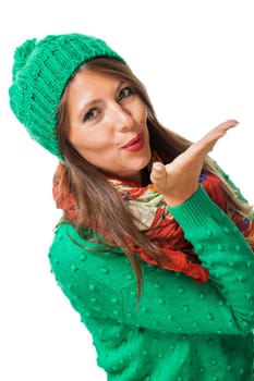 Young attractive woman with green wool hat with kiss mouth throws a kiss to isolated against white background