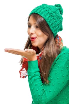 Young attractive woman with green wool hat with kiss mouth throws a kiss to isolated against white background