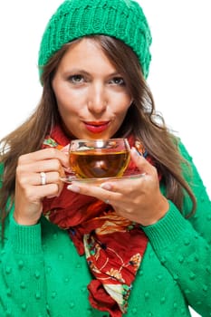Attractive woman with green wool hat in winter drinks a cup of tea isolated against a white background