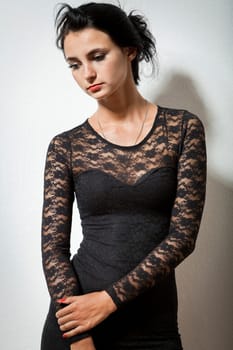 attractive woman with long dark hair in black cocktail dress as portrait with text space