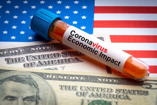 CORONAVIRUS ECONOMIC IMPACT text, US Dollar and blood sample vacuum tube on America flags background. Covid-19 or Coronavirus Concept