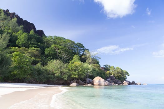 A beach on the Seychelles island with white sand and stones