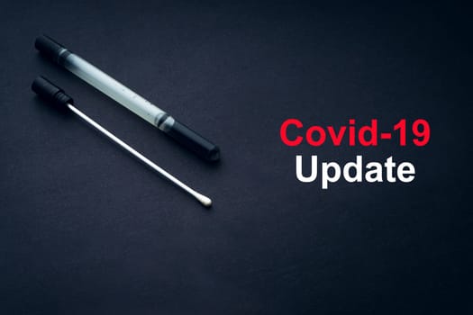 COVID-19 or CORONAVIRUS UPDATE text with medical swab on black background. Covid-19 or Coronavirus concept.