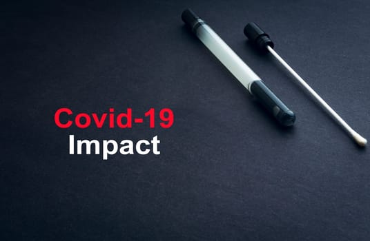 COVID-19 or CORONAVIRUS IMPACT text with medical swab on black background. Covid-19 or Coronavirus concept.