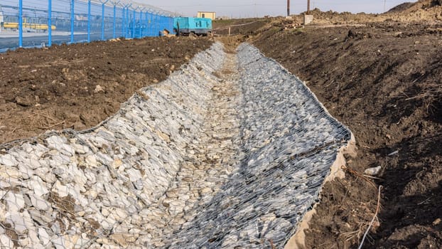 Gabion and gutter construction along the road