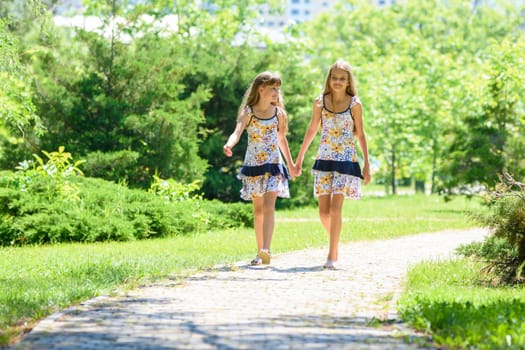 girls walk in the park and chat with each other
