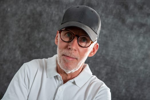 a sixty year old man wearing a baseball cap