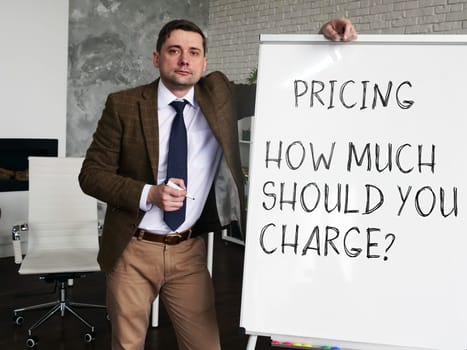 Pricing strategy - How Much Should You Charge. Business Advisor at the blackboard with the inscription.
