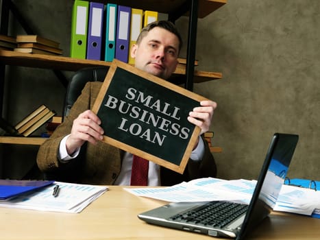 Businessman shows phrase small business loan.