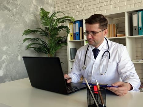 Telemedicine concept. A Doctor works with laptop.