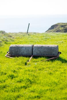 old rustic concrete roller abandoned at a field in ireland