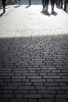 commuters walking down a cobbled lane in london city