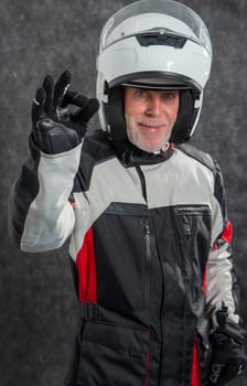 aportrait of senior biker with a white helmet make OK