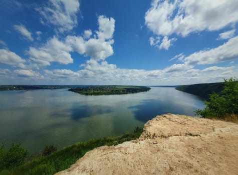 High angle, altitude view to the Nistru river, near Dubasari (Dubossary), Transnistria, Moldova. Idyllic panoramic scene on the peak of a cliff over the water under a rich blue sky.