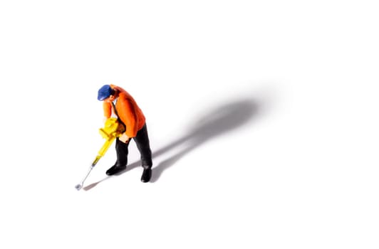 Little People Builder worker with pneumatic hammer drill equipment on white background. Shot from above with shadow
