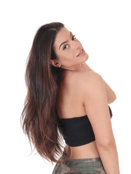 A lovely smiling young woman standing in the studio in profile.with her long brunette hair, isolated for white background.