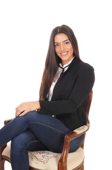 A gorgeous young woman sitting in jeans and a black jacket.smiling, isolated for white background.
