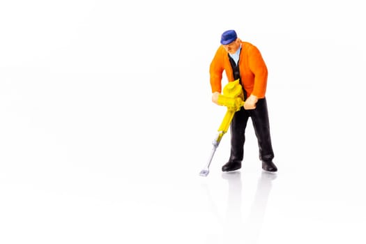 Little People Builder worker with pneumatic hammer drill equipment on white background with reflection