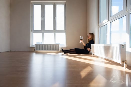Beautiful elegant girl sits on the floor in a large light room with stained glass windows