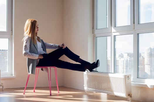 empty room with a girl sitting on a chair in front of the window