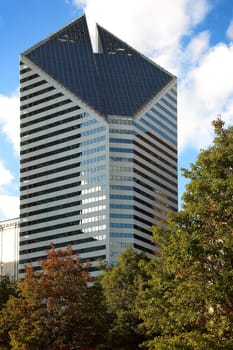 CHICAGO, ILLINOIS/USA-OCTOBER 16 2015: Crain Communications Building Chicago with autumn trees Millennium Park on October 16 2015, Chicago, Illinois