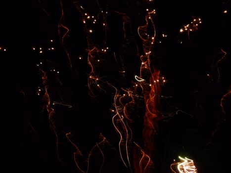 Autumnal colors of red and orange fireworks sparkle away in a black nights sky to form this abstract frame of warmth. Great for background use.