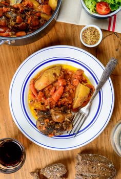 a beef plate with carrots on a old wooden table