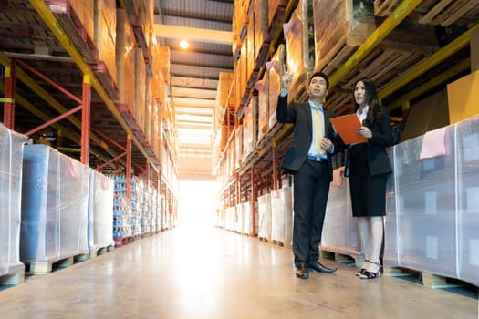 Portrait of businessman discuss with businesswoman about inventory with factory warehouse. Business distribution warehouse concept.