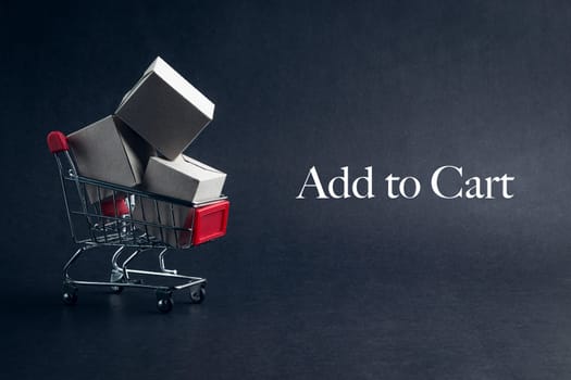 Shopping cart with words ADD TO CART on dark background. Business, Copy space and online shopping concept. Selective focus