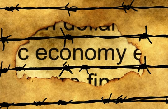 Economy text on paper hole against barbwire