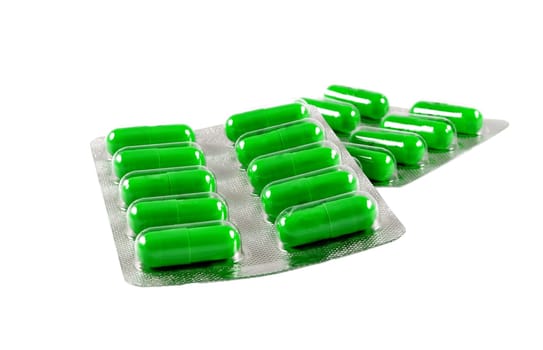 green antibiotic pills on white background