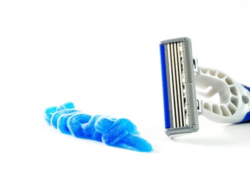 Closeup of blue shaving blade with foam on white surface