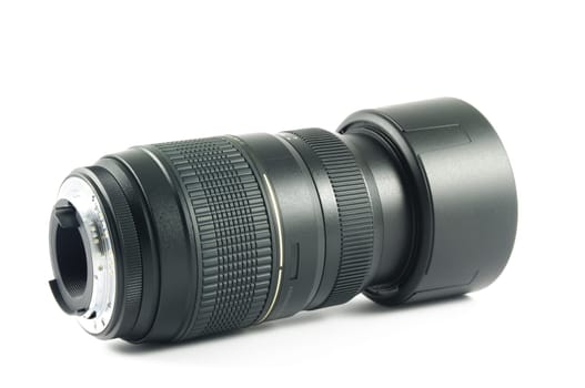 Camera lens with hood lying on the white surface