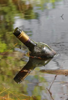 old bottle in dirty lake water