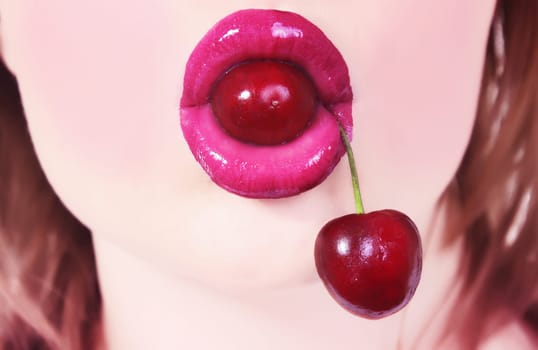 closeup of woman's lips with cherry