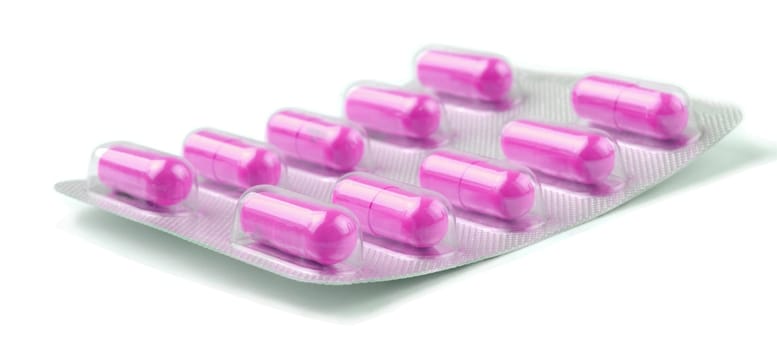 pink  medicine pills over white