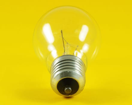 Light bulb closeup over yellow surface
