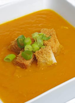 pumpkin soup with crackers and onion