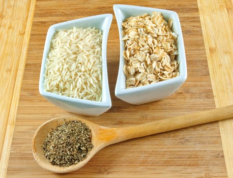 rice, oats and herbs on the wooden board