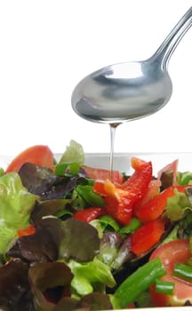 spoon with oil over fresh salad