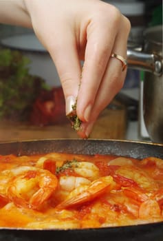 adding herbs to delicious prawns