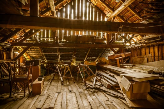 Interior of old wooden shed with scrap wood with sunrays. Old barn.