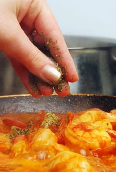 adding herbs to delicious prawns