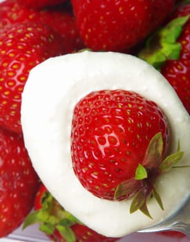 strawberry closeup with cream on the spoon