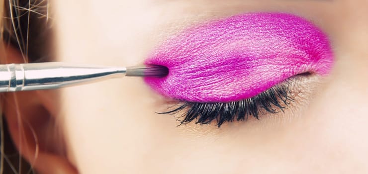 woman applying glamour eye shadows