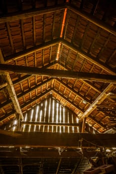 Interior of old wooden shed with scrap wood with sunrays. Old barn.